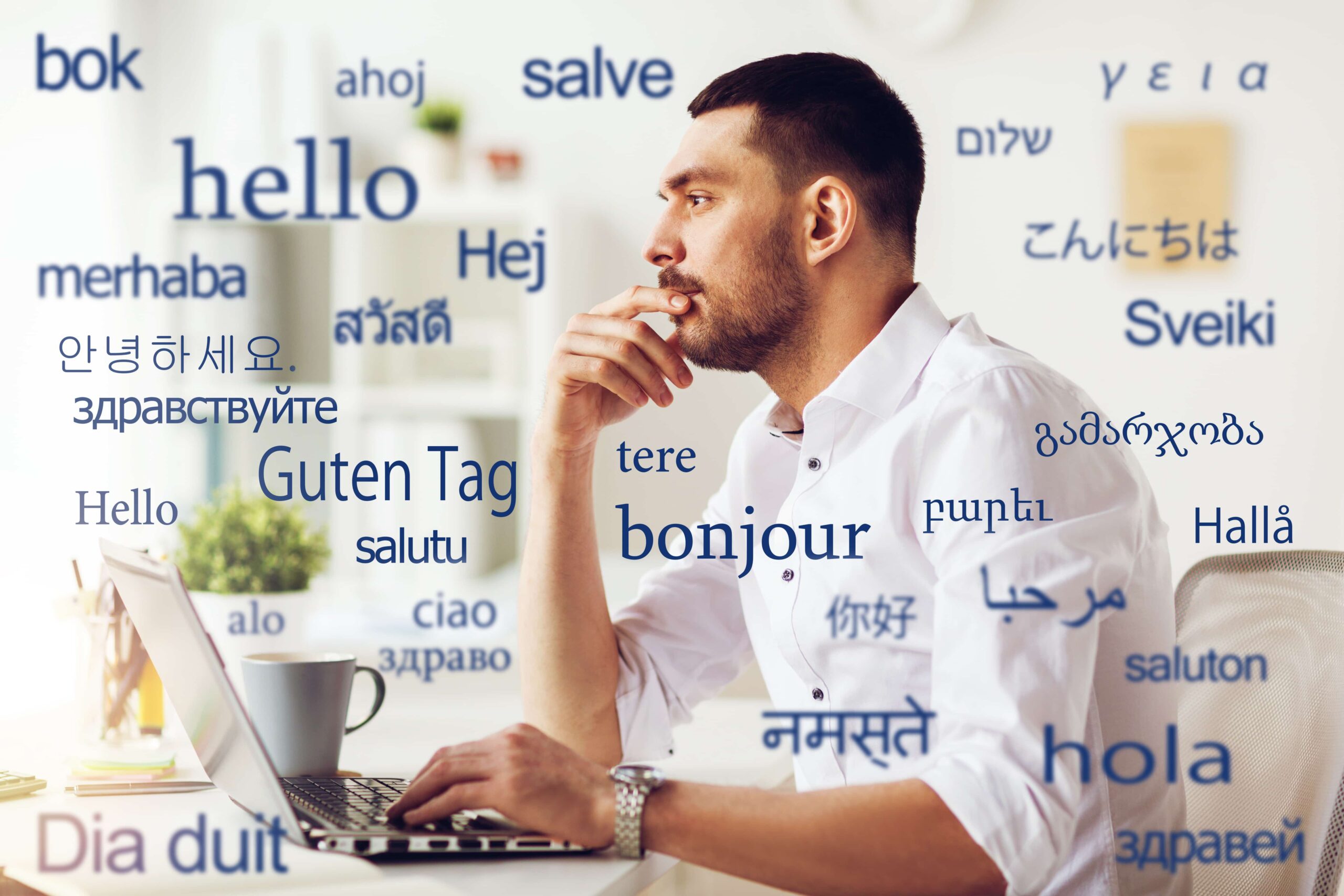 Hombre en el ordenador rodeado de palabras en diferentes idiomas.