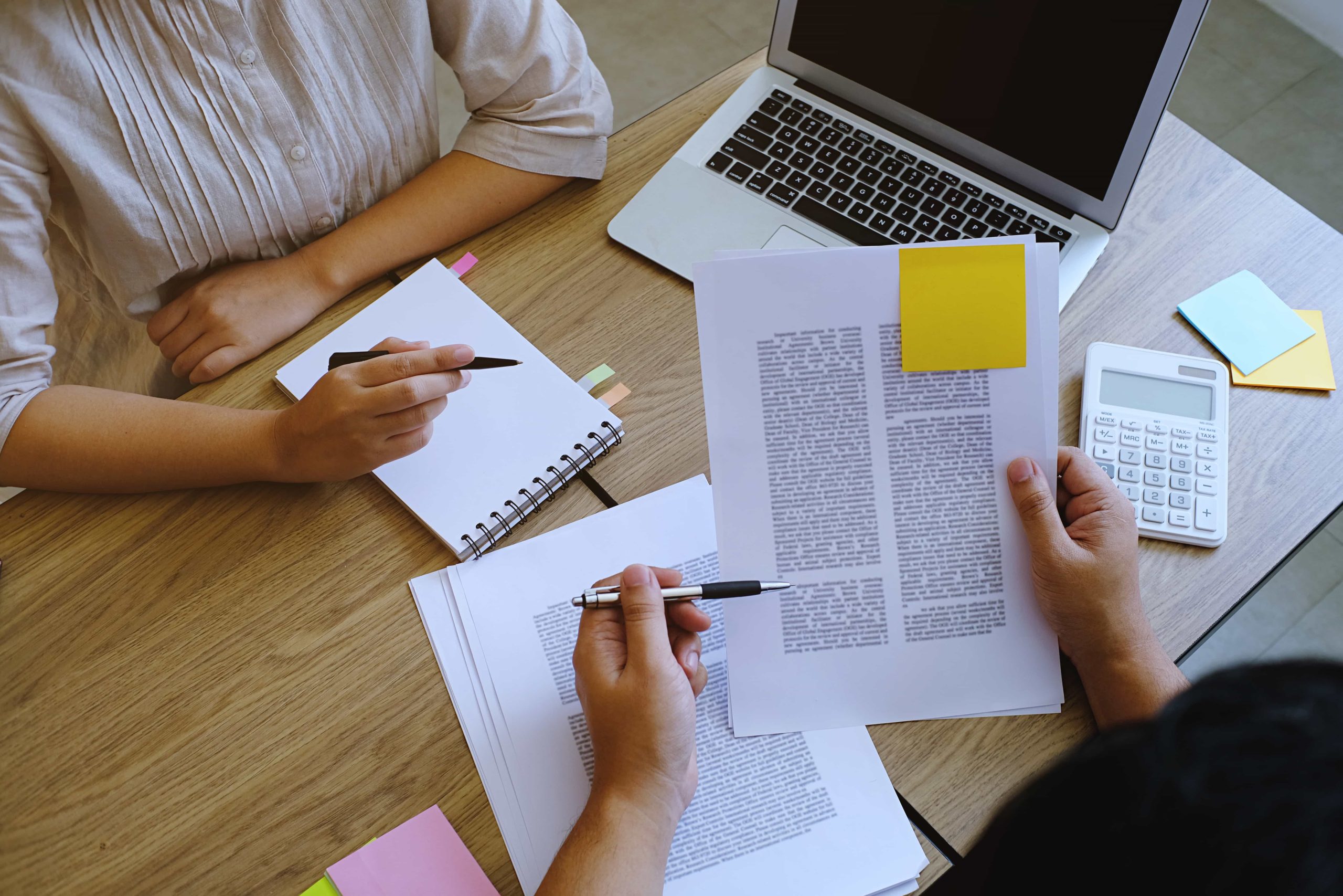Imagen de dos personas revisando los textos comerciales con correcciones.